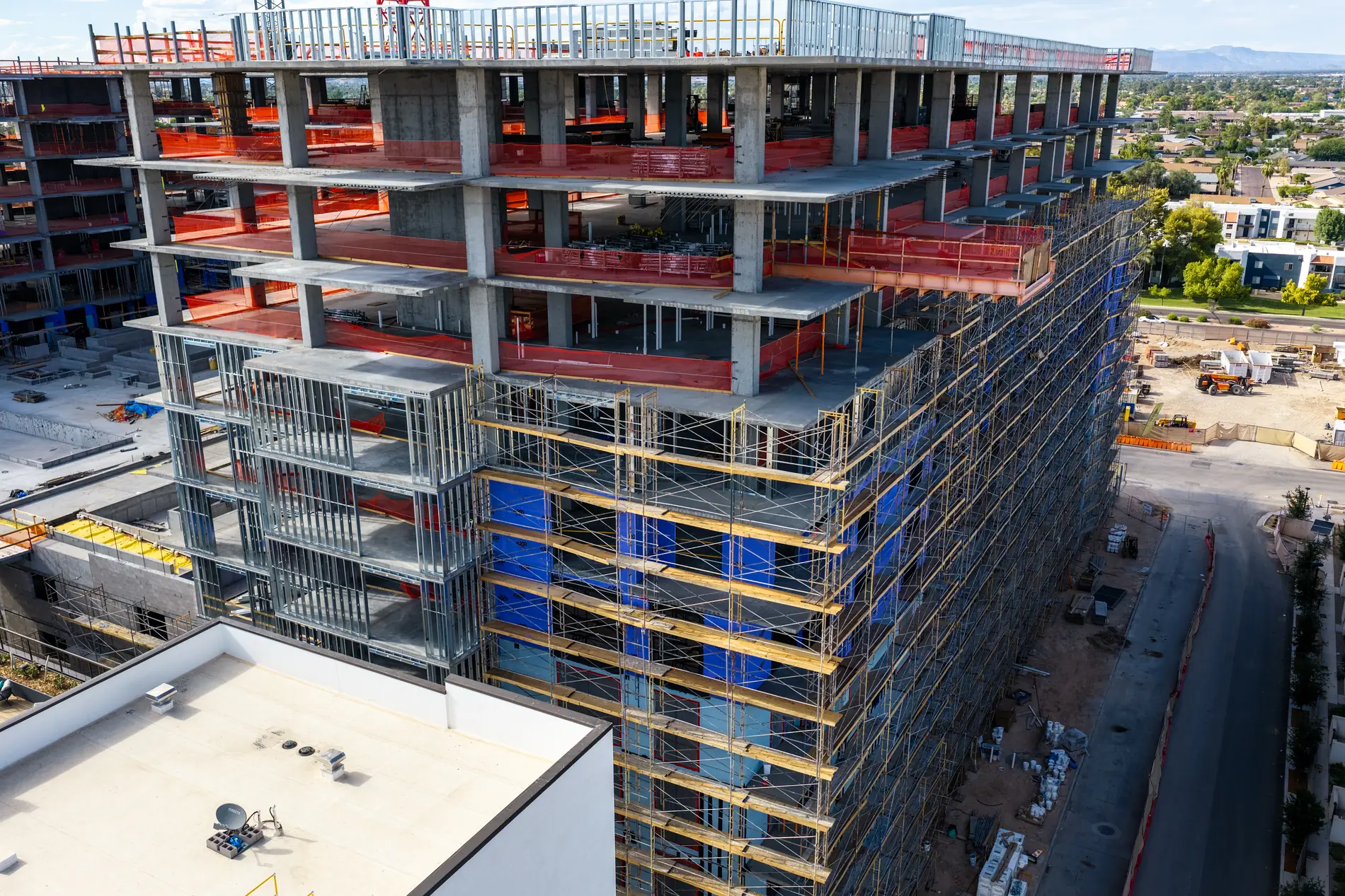 Scaffolded elevation showing weather barrier, metal stud framing and open floor plates