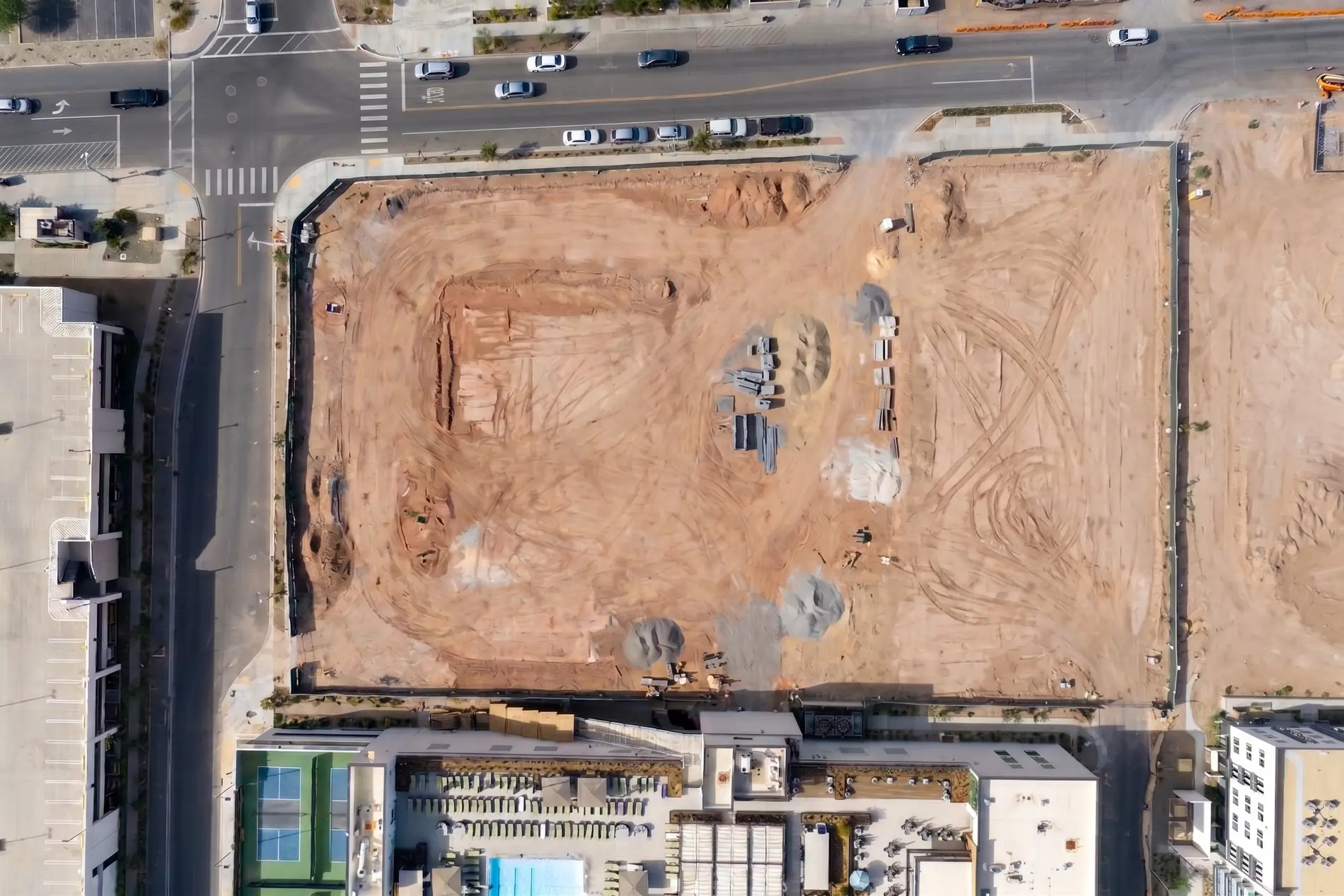 Top-down aerial of the site as bare graded dirt before construction